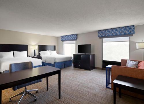 a hotel room with two beds and a table and chairs at Hampton Inn & Suites Arundel Mills/Baltimore in Hanover