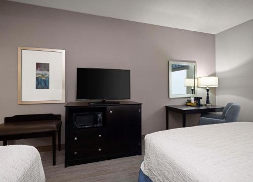 a hotel room with two beds and a flat screen tv at Hampton Inn & Suites Arundel Mills/Baltimore in Hanover