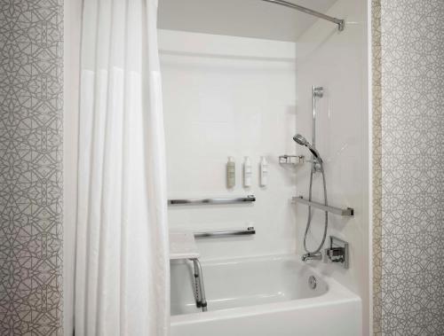 a bathroom with a white shower curtain and a sink at Hampton Inn & Suites Arundel Mills/Baltimore in Hanover