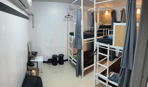DonMueang station hostel في Ban Don Muang (1): غرفة بها ثلاثة أسرة بطابقين