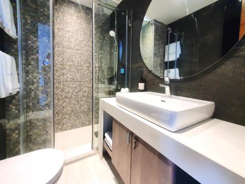 a bathroom with a sink and a shower and a toilet at Majestic Palm Beachfront Exotic Room in Batroun in Fghāl