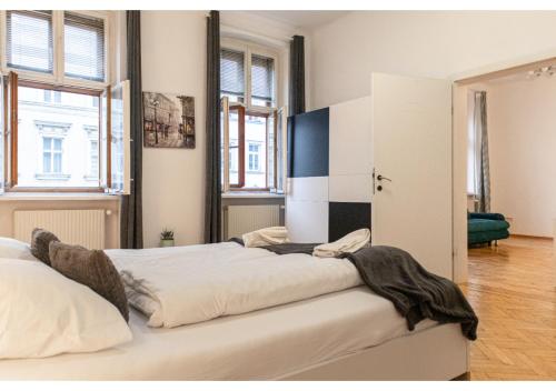 1 dormitorio con 1 cama grande en una habitación con ventanas en Deluxe 3BR Apt. Wiener Stadthalle - Suitable for Longstays, en Viena