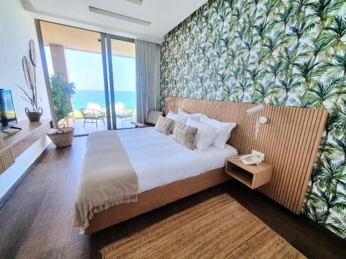 een slaapkamer met een groot bed met tropisch behang bij Majestic Palm Beachfront Exotic Room in Batroun 