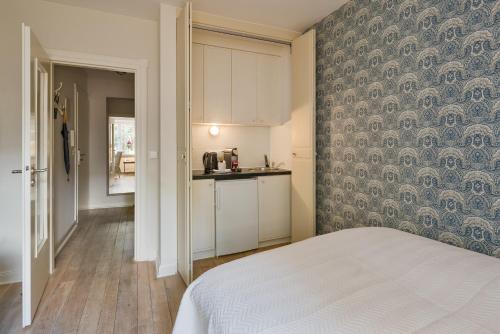 a room with a bed and a kitchen with a wall at von Deska Townhouses - Ivy House in Hamburg