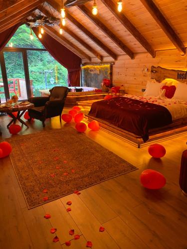 Çamlıhemşin的住宿－Hoşdere Suit，卧室配有一张床,地板上摆放着红色鲜花