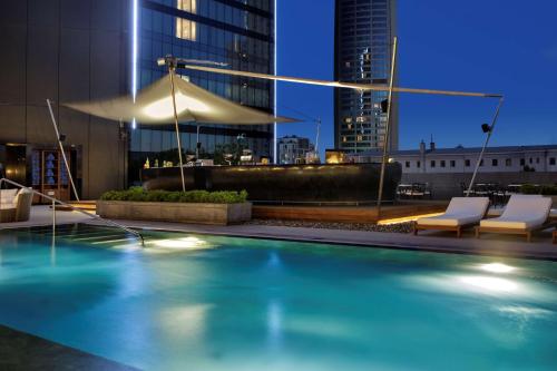 a swimming pool with two chairs and a building at Hilton Istanbul Bomonti in Istanbul