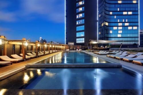 a pool on the rooftop of a building at night at Hilton Istanbul Bomonti in Istanbul