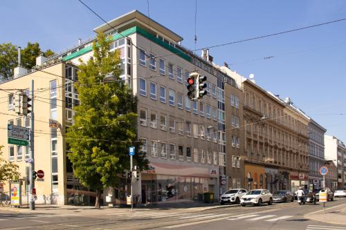 ein Gebäude in einer Stadtstraße mit einer Ampel in der Unterkunft Modern - Neu - Gemütlich - Self Checkin - zentral - Straßenbahn 38 zum Ring in Wien