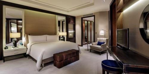 a bedroom with a large bed and a desk and a television at Hilton Istanbul Bomonti in Istanbul