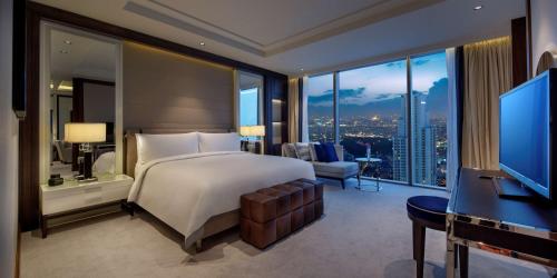 a bedroom with a bed and a desk and a television at Hilton Istanbul Bomonti in Istanbul