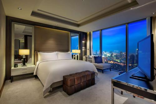 a bedroom with a bed and a desk and a television at Hilton Istanbul Bomonti in Istanbul