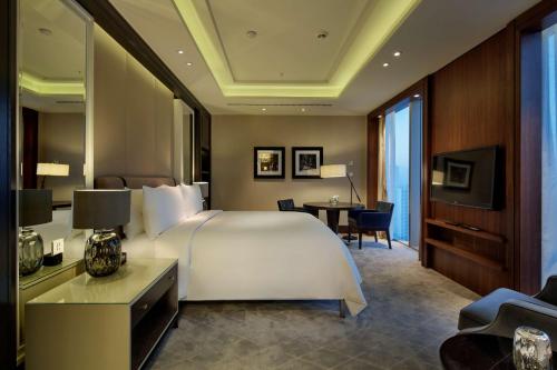 a bedroom with a large white bed and a desk at Hilton Istanbul Bomonti in Istanbul