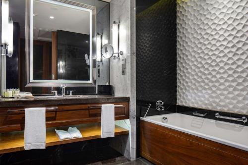 a bathroom with a tub and a sink and a bath tub at Hilton Istanbul Bomonti in Istanbul