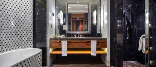 a bathroom with a sink and a tub and a mirror at Hilton Istanbul Bomonti in Istanbul