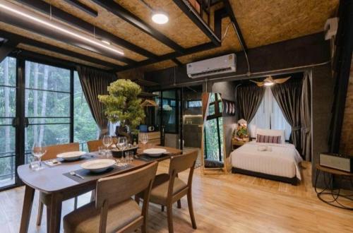 a dining room with a table and a bedroom at Grandfather Khaolak Resort in Khao Lak