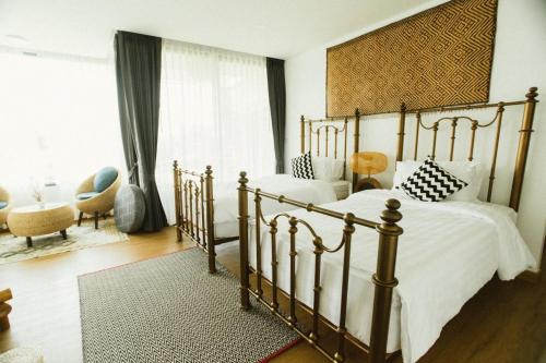 a bedroom with two beds and a large window at Pupah Kanna Pua-ปู๋ ป๋าล์ คันนา ปัว in Pua