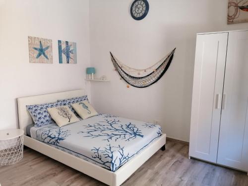 a bedroom with a bed and a clock on the wall at Blue Cottage monolocale centro Sciacca in Sciacca