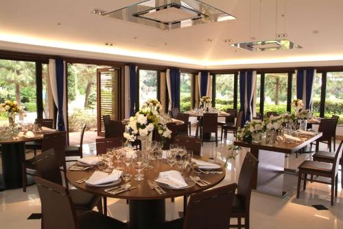 a dining room with tables and chairs and windows at Hilton Tokyo Bay in Urayasu