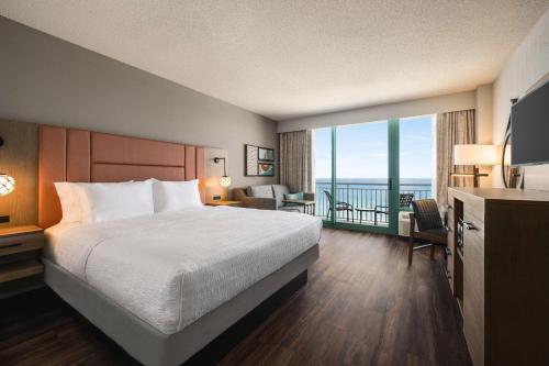 a hotel room with a bed and a balcony at Hampton Inn Virginia Beach-Oceanfront South in Virginia Beach