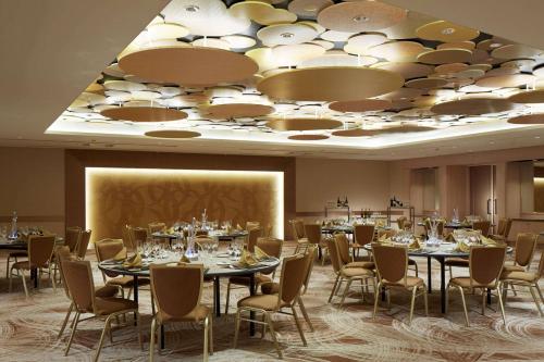 a conference room with tables and chairs and a projector at Hilton Tokyo Bay in Urayasu