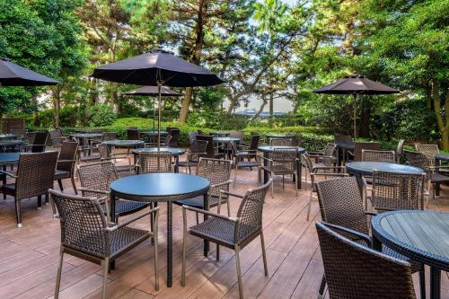 an outdoor patio with tables and chairs and umbrellas at Hilton Tokyo Bay in Urayasu