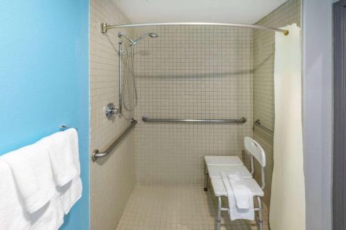 a bathroom with a shower and a toilet with towels at La Quinta by Wyndham New Braunfels in New Braunfels