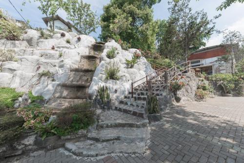 a set of stone stairs with potted plants at Urbanview Hotel D'Pineapple Villa Ciater by RedDoorz in Subang