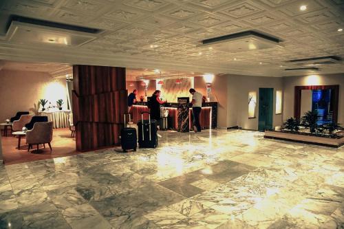 a lobby with people standing at a counter at Hotel Continental in Kairouan