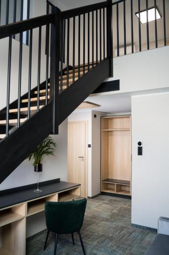 an office lobby with a staircase and a green chair at BULVAR in Malbork