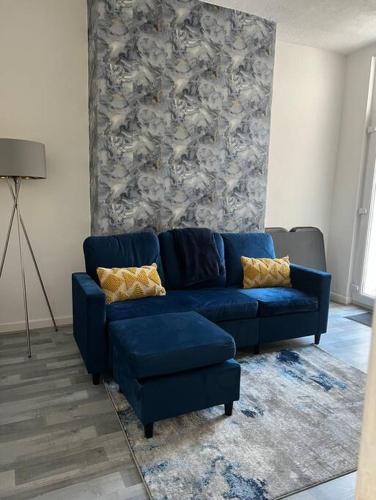 um sofá azul sentado numa sala de estar em spacious 3 bed - EFC stays em Liverpool