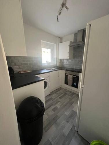 a kitchen with white cabinets and a black counter top at spacious 3 bed - EFC stays in Liverpool