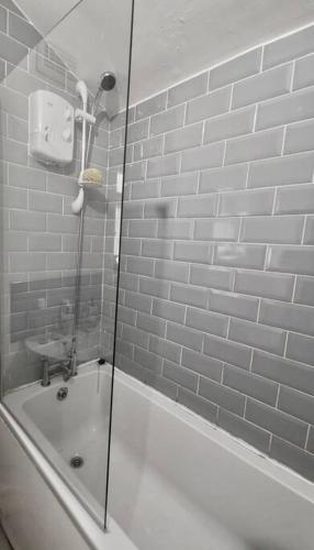 a shower with a glass door next to a tub at spacious 3 bed - EFC stays in Liverpool