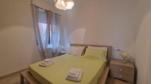 um quarto com uma cama com lençóis verdes e uma janela em WH - Bussana em Sanremo