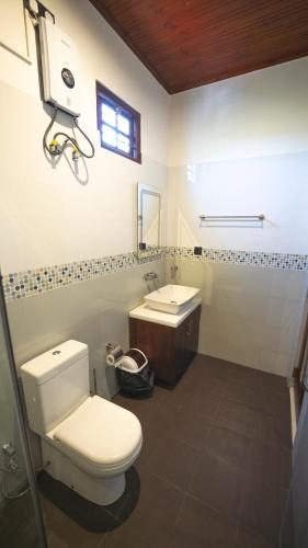 a bathroom with a toilet and a sink at JAMUNA VILLA in Jaffna