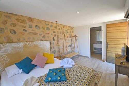 een slaapkamer met een bed met kleurrijke kussens erop bij Villa Bergeries De Calvi in Calvi