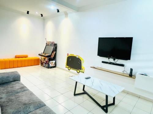 ein Wohnzimmer mit einem Sofa und einem Flachbild-TV in der Unterkunft EE Summer Guest House 3.0 in Seremban