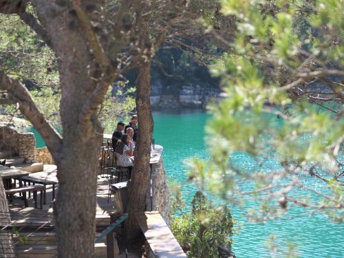 un grupo de personas sentadas en mesas frente a un lago en Moli l'Abad en Puebla de Benifasar