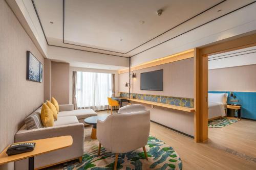 Habitación de hotel con sofá y cama en Hilton Garden Inn Guangzhou Airport Aerotropolis, en Huadu