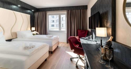 una camera d'albergo con 2 letti e una scrivania di PLAZA INN Wiener Neustadt, BW Signature Collection a Wiener Neustadt
