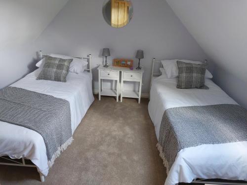 two twin beds in a attic room with a table at southview in Portskerra