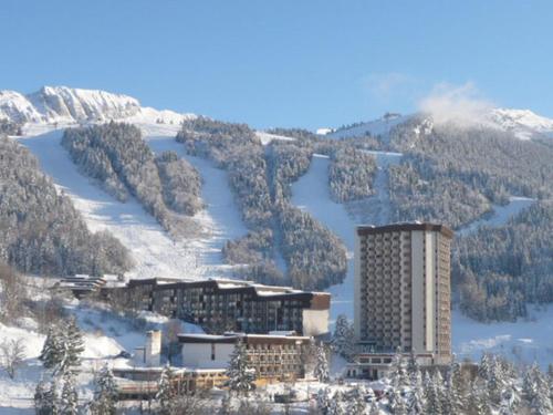 un hôtel au sommet d'une montagne dans la neige dans l'établissement Studio rénové 4 personnes, pied des pistes, balcon sud, TV/DVD, cuisine équipée, parking gratuit. - FR-1-689-97, à Villard-de-Lans