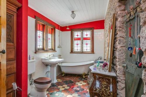 a bathroom with a tub and a toilet and a sink at Benny's Beach House in Encounter Bay