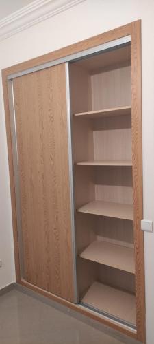 a closet with wooden doors and shelves in a room at APPARTEMENT haut standing in O Ben Slimane