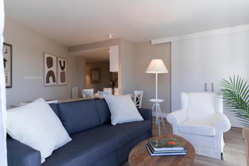 a living room with a blue couch and a white chair at Apartamentos Plaza Center in Suances