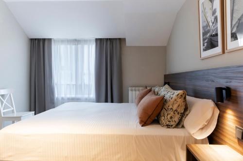 a bedroom with a large bed with pillows on it at Apartamentos Plaza Center in Suances