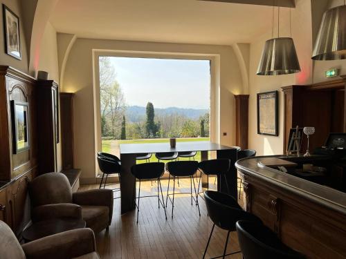 a kitchen with a table and chairs and a large window at Hôtel Villa Navarre in Pau