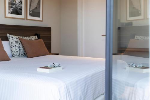 a bedroom with a white bed with two trays on it at Apartamentos Plaza Center in Suances