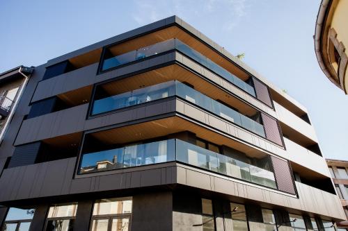 a tall building with glass windows on the side of it at Apartamentos Plaza Center in Suances