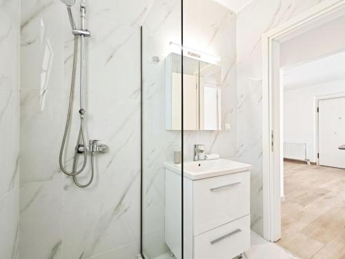 a white bathroom with a shower and a sink at Marathonomachon by Verde Apartments in Athens
