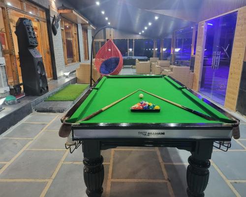 a pool table in a room with a pool ball at Hotel Smugglers Mountain View - central heated & air Cooled in Manāli